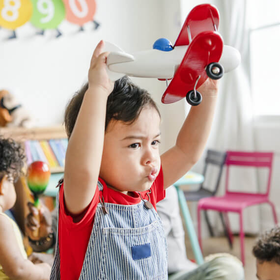 preschooler-enjoying-playing-with-his-airplane-toy-PRDTCJ4
